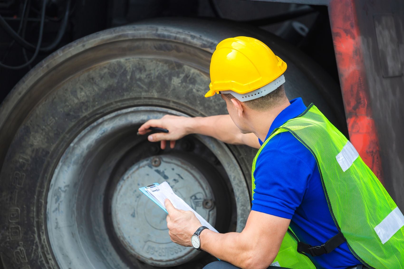 Mechanics checking wheel in cargo container